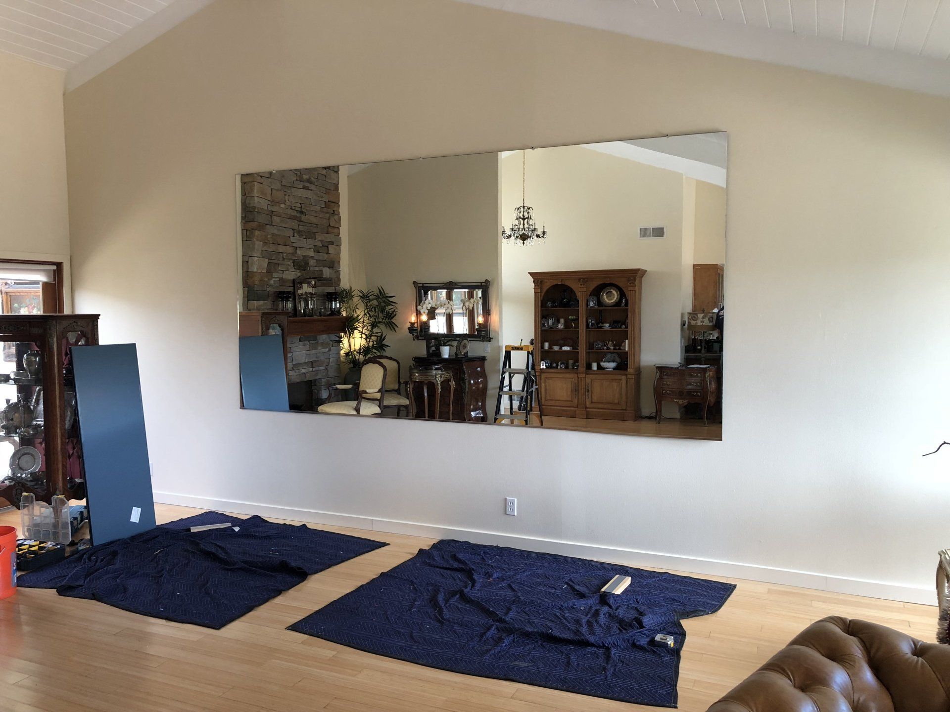 A large mirror is hanging on a wall in a living room.