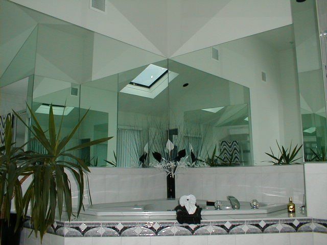 A bathroom with a jacuzzi tub and a large mirror