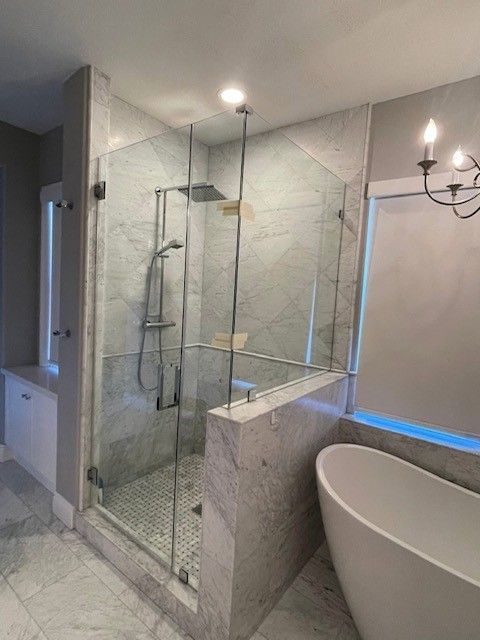 A bathroom with a walk in shower and a bathtub.