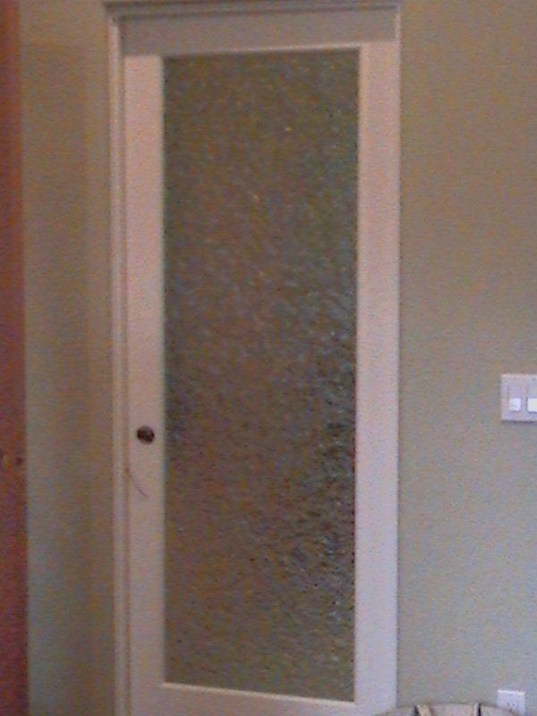 A white door with a glass panel in a room.