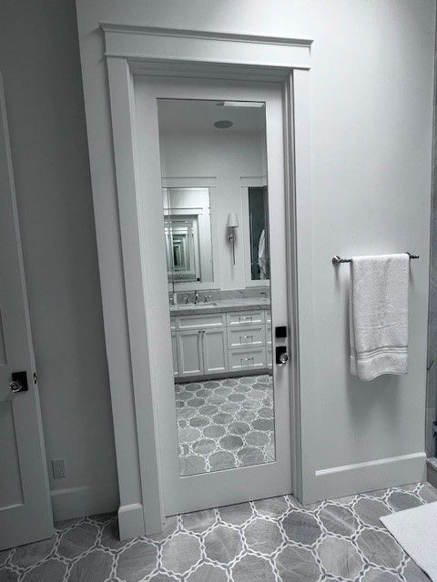 A bathroom with a full length mirror in the doorway.
