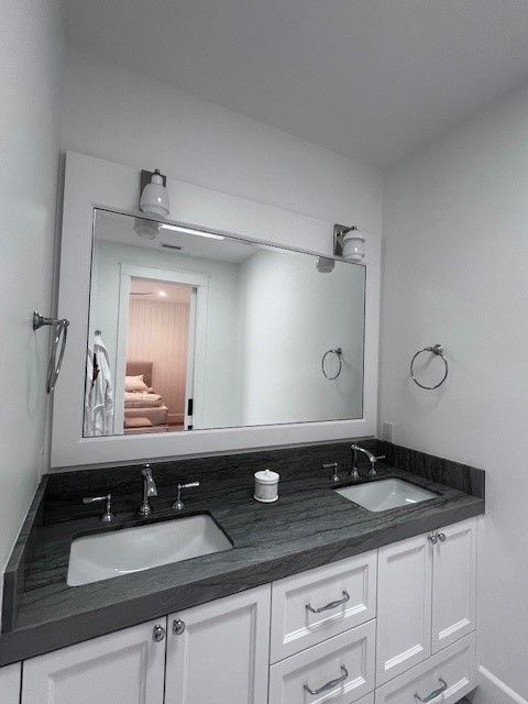 A bathroom with two sinks and a large mirror.