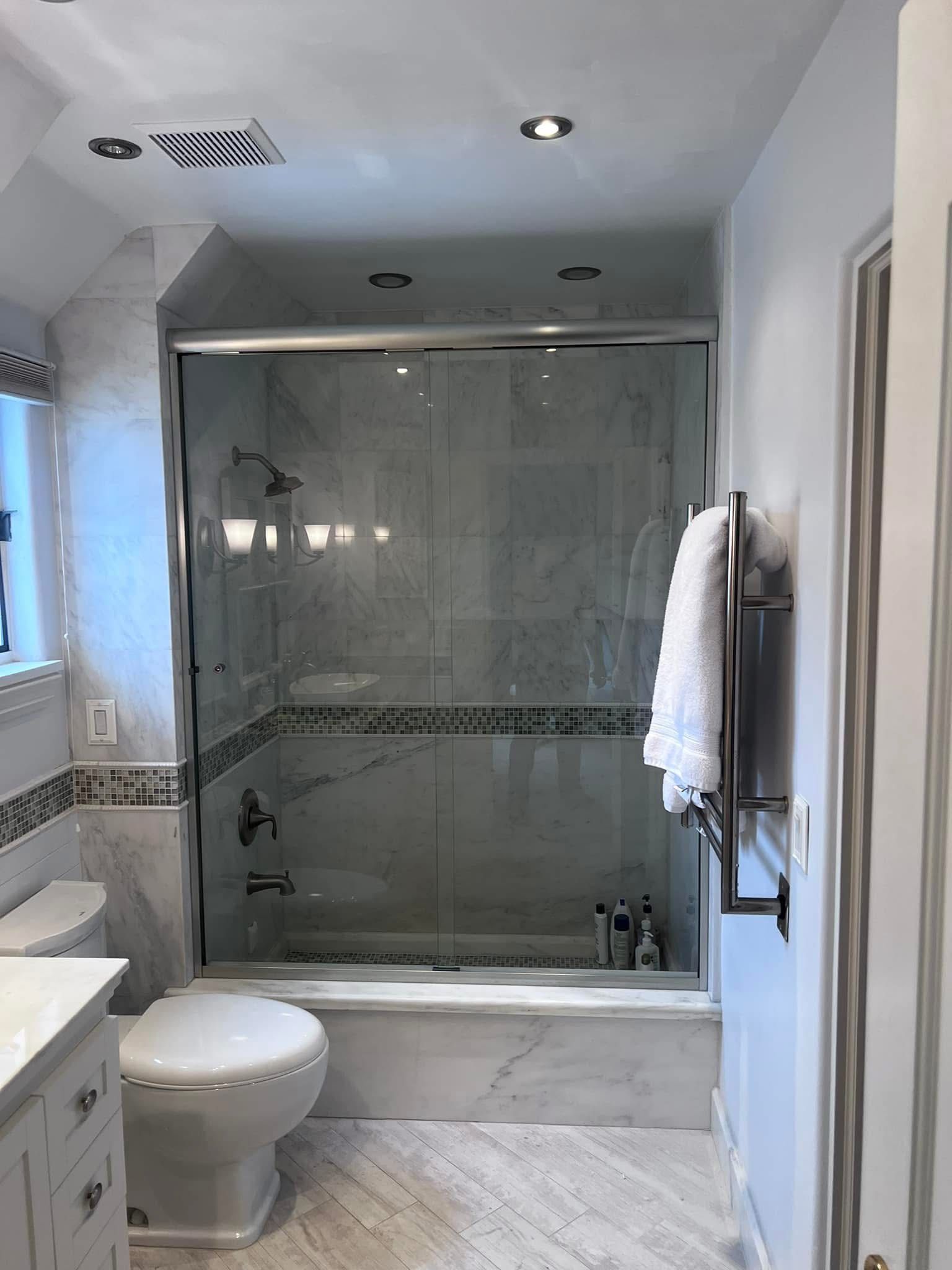 A bathroom with a toilet , sink , shower and bathtub.