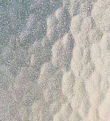 A close up of a sandy surface with a blue sky in the background.