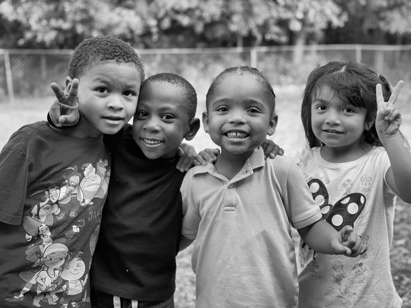 A group of children are posing for a picture together in a black and white photo.