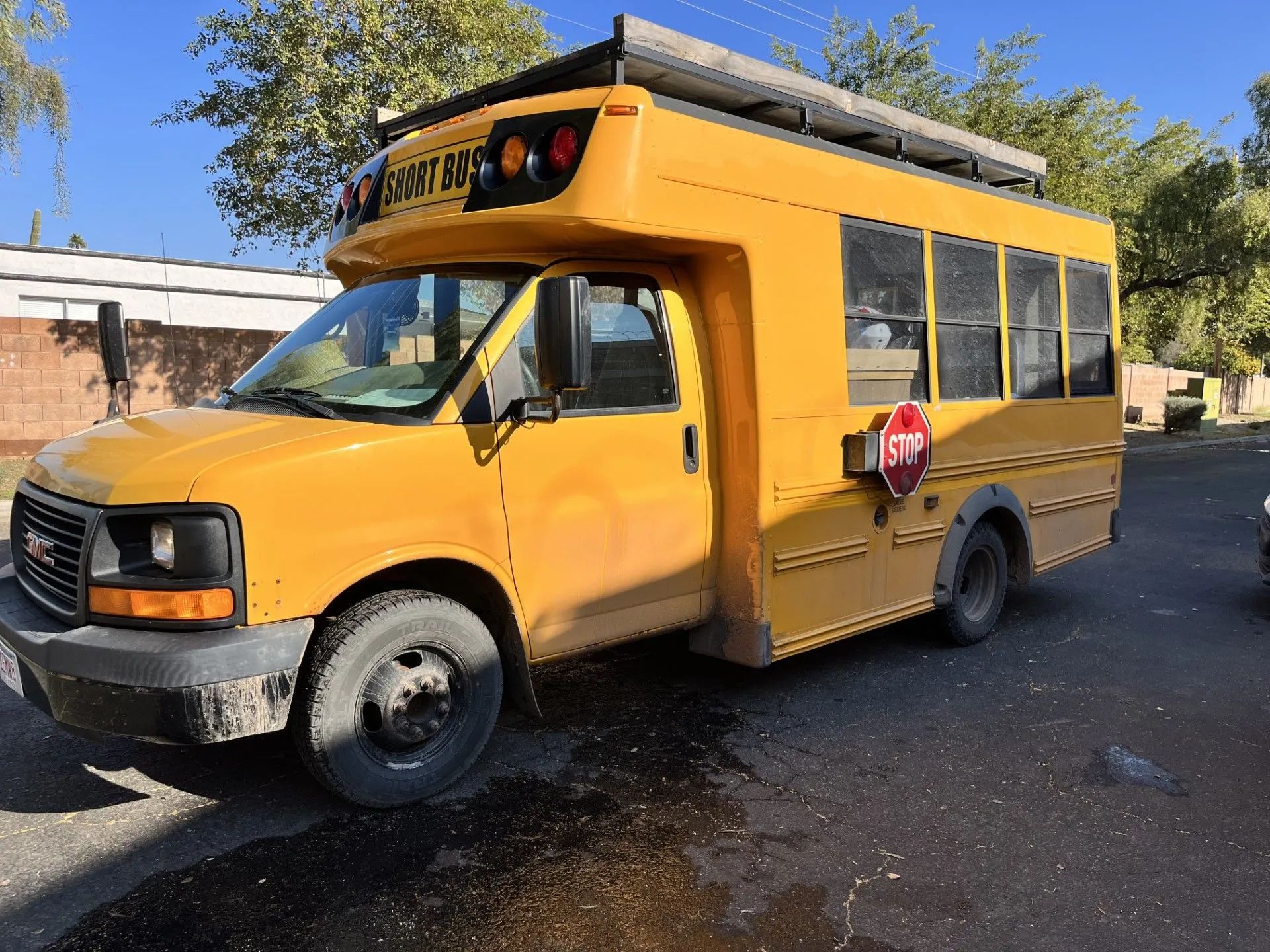 Yellow school bus parked on a paved street with a stop sign.