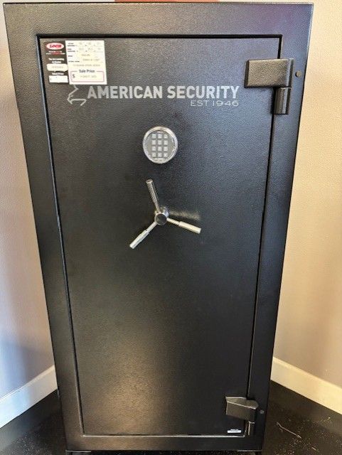 A black American Security gun safe with a combination lock and handle.