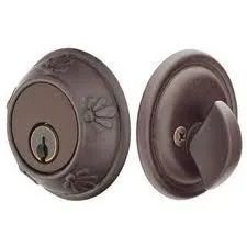 Two bronze-colored door deadbolts; one with a keyhole, the other with a thumbturn.