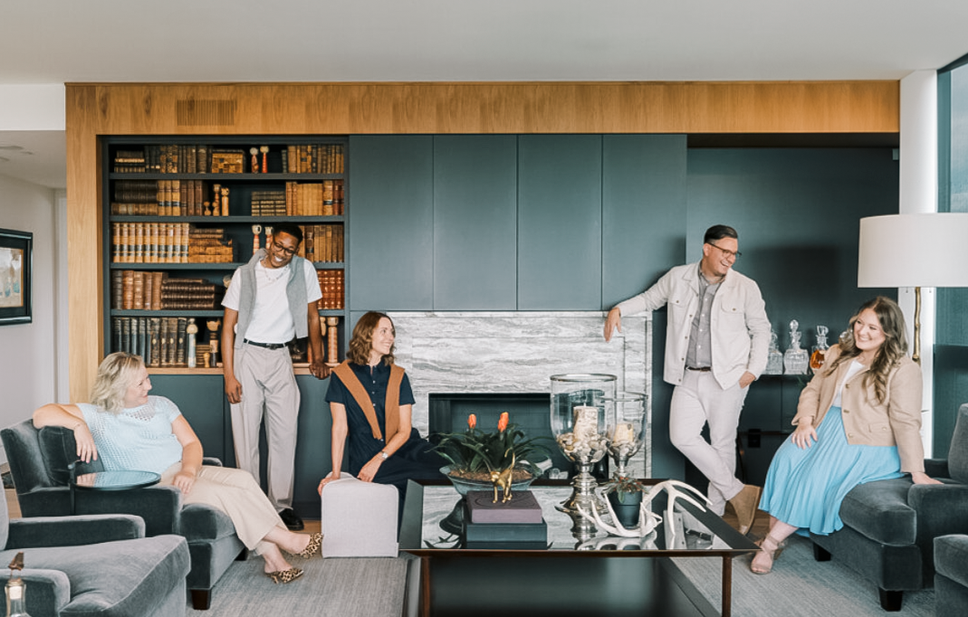 Four people pose for a photo in an interior design studio.