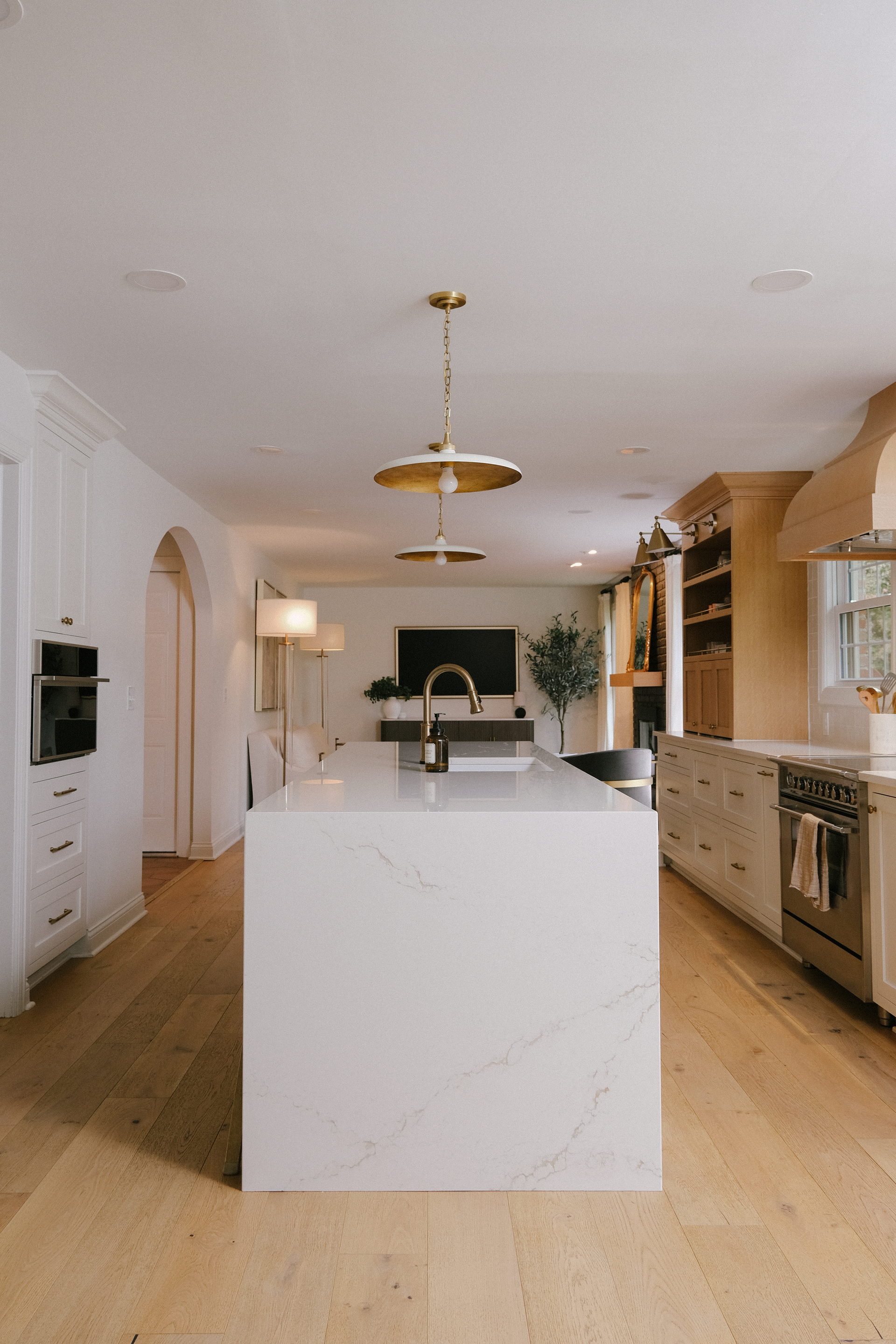 Navy blue kitchen with white countertops, wooden bar stools, and checkered floor.