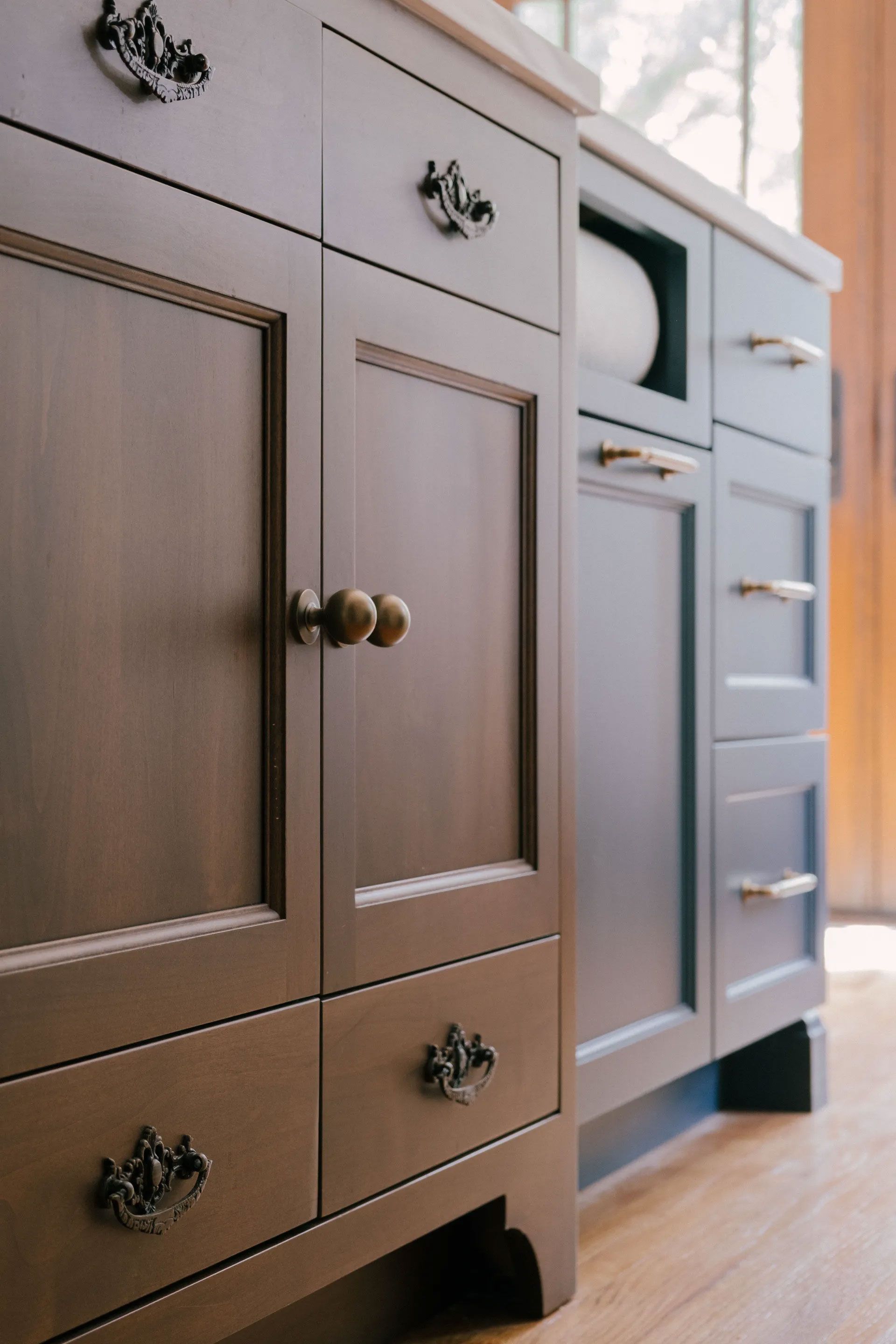Dark brown and blue kitchen cabinets with ornate hardware.