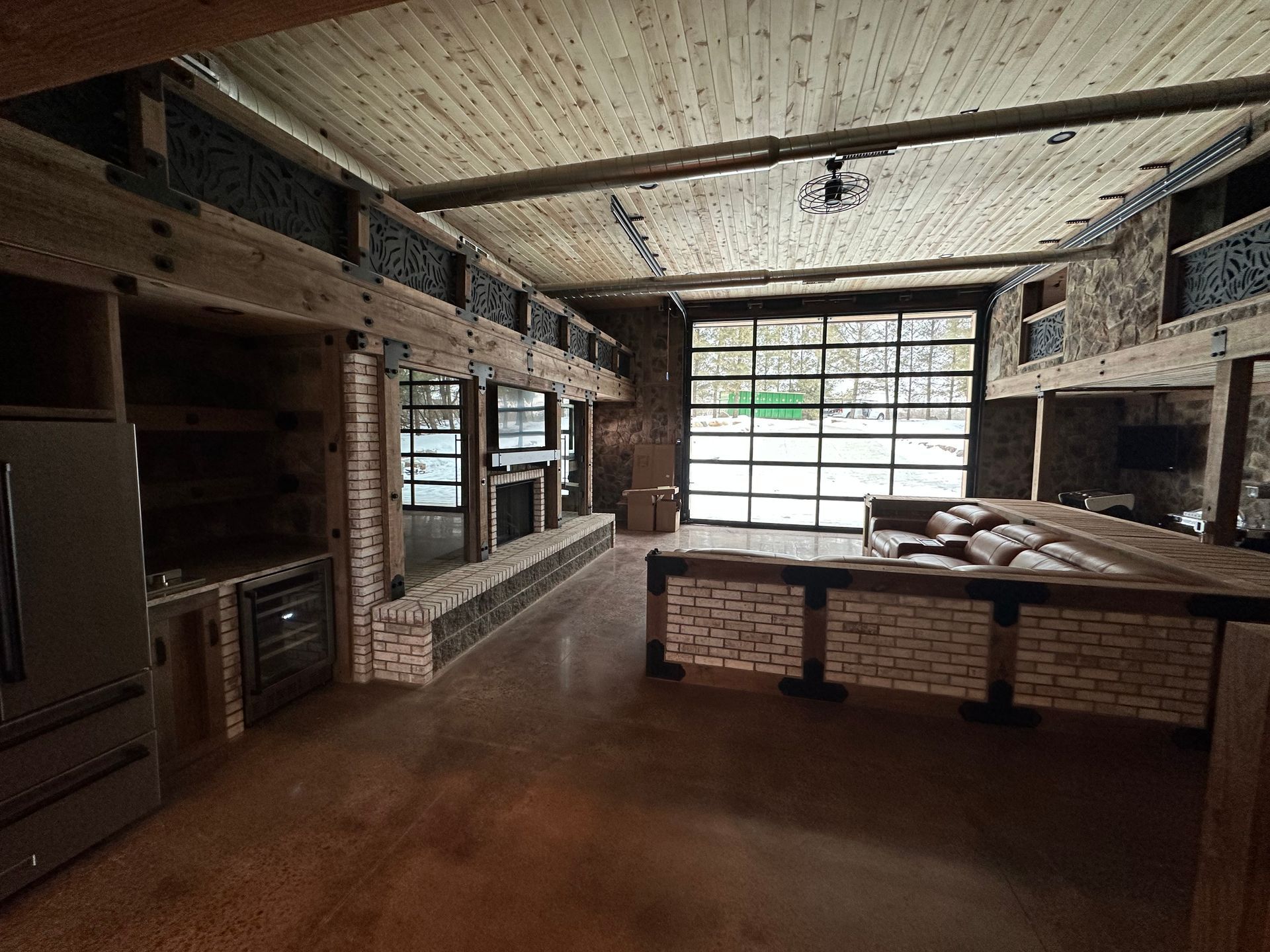 Rustic interior with exposed beams, brick accents, and a large glass garage door.