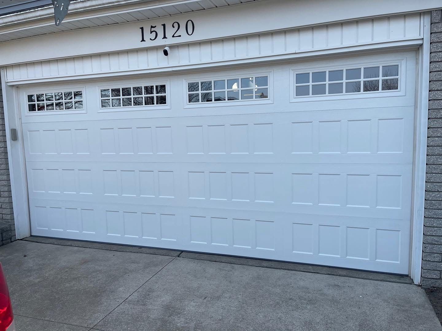 White garage door with windows, address numbers 