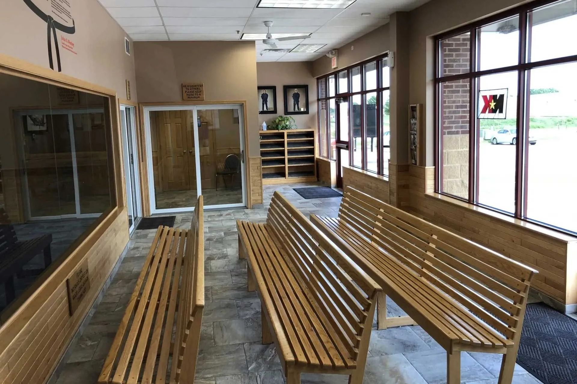 Hallway with wooden benches, a glass window, and a beige interior.