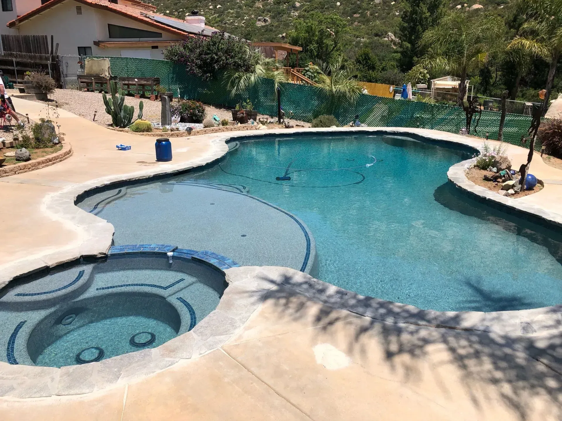 Pool with turquoise water, a connected spa, and concrete deck in a sunny outdoor setting.