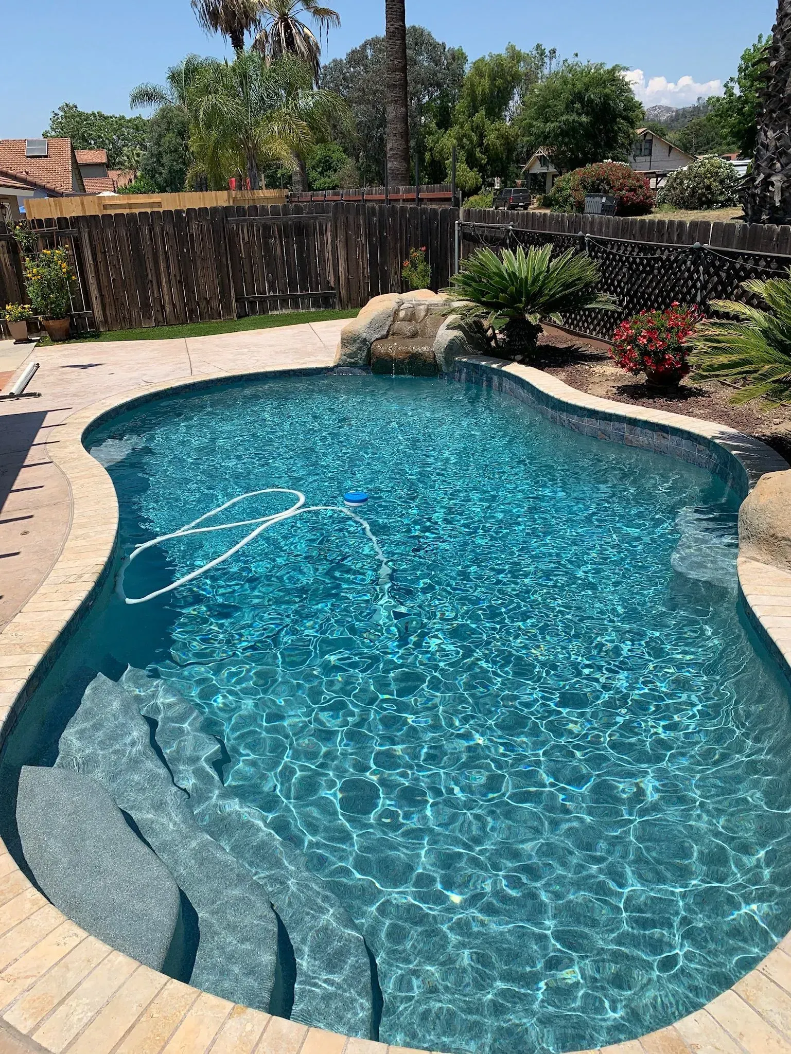 Swimming pool with blue water and stone steps.