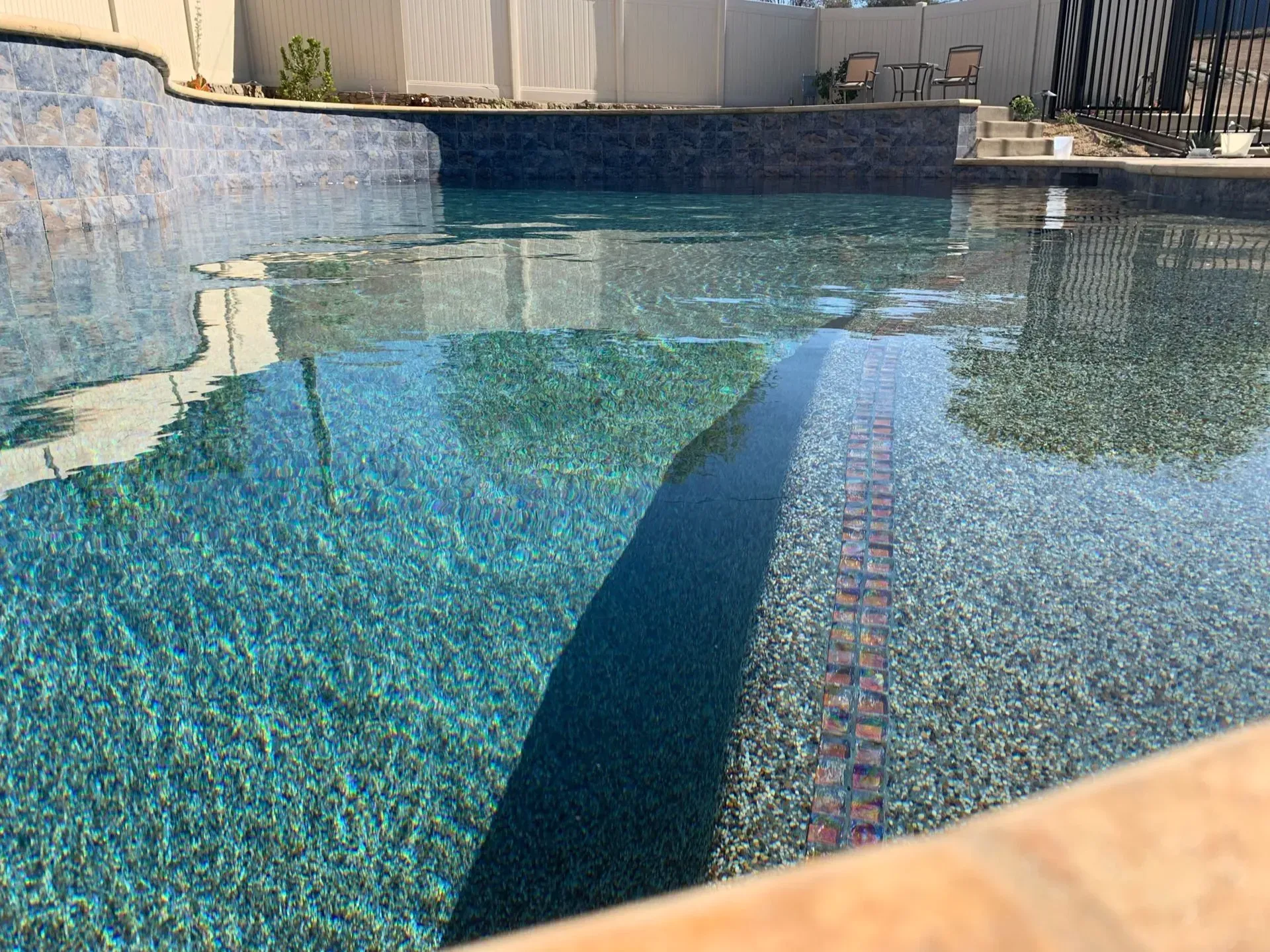 Pool with blue-green water and tiled walls. Sunlight reflects off the water's surface.