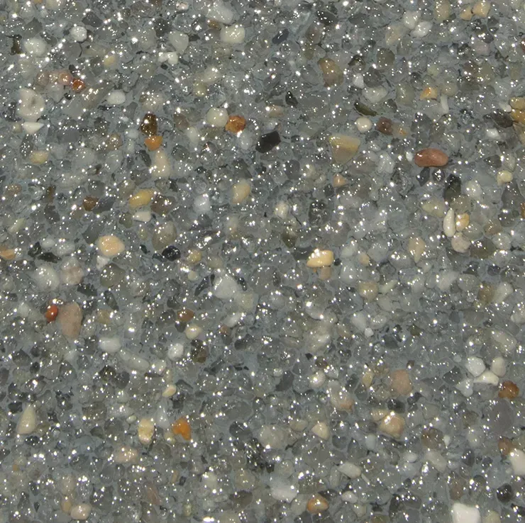 Close-up of a polished concrete surface with embedded, small pebbles in various colors.