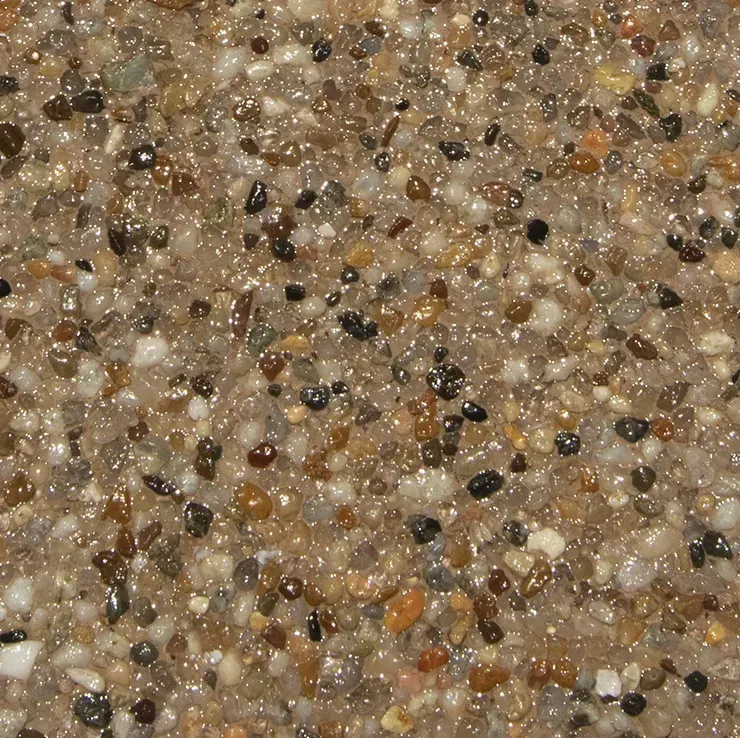 Close-up of a speckled, textured surface of small, shiny pebbles in various shades of brown and beige.