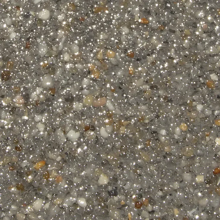 Close-up of a speckled, gray surface with reflective, shiny particles, resembling polished aggregate.