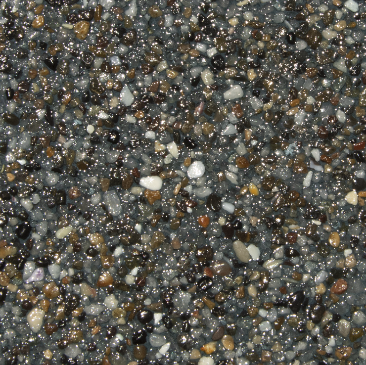 Close-up of a speckled, glossy surface made of small, multicolored pebbles.
