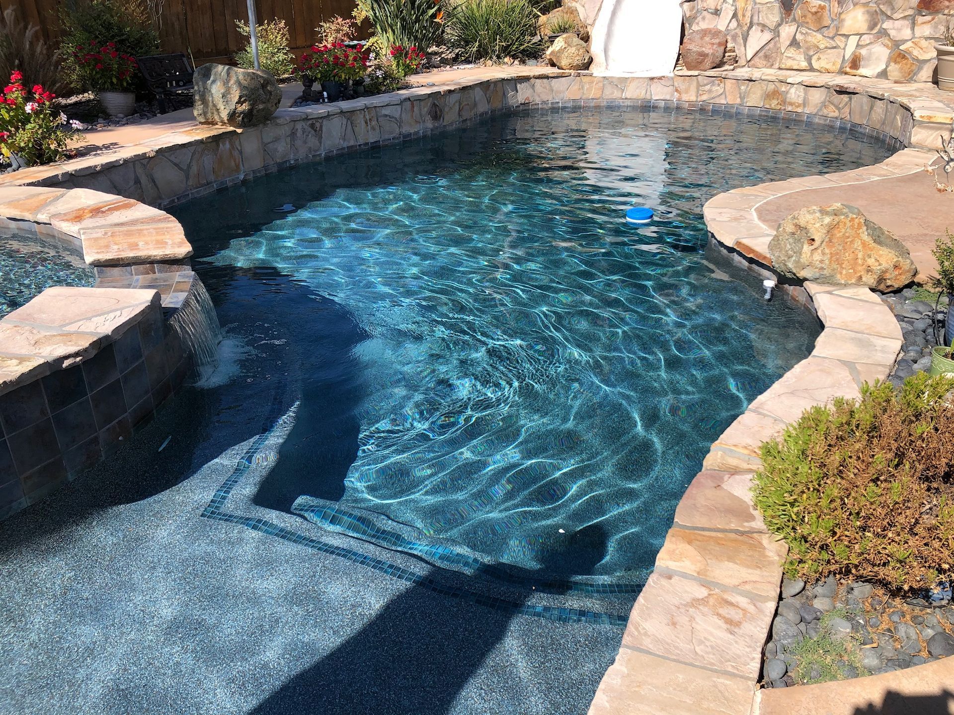 Pool with dark blue water and stone edging.