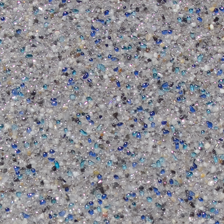 Close-up of a speckled surface with blue and black glass pieces embedded in gray aggregate.
