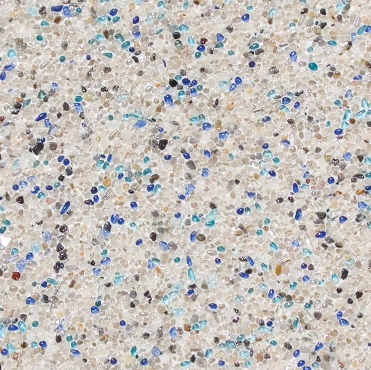 Close-up of a speckled beige surface with scattered blue and black pebbles; likely a pool finish.
