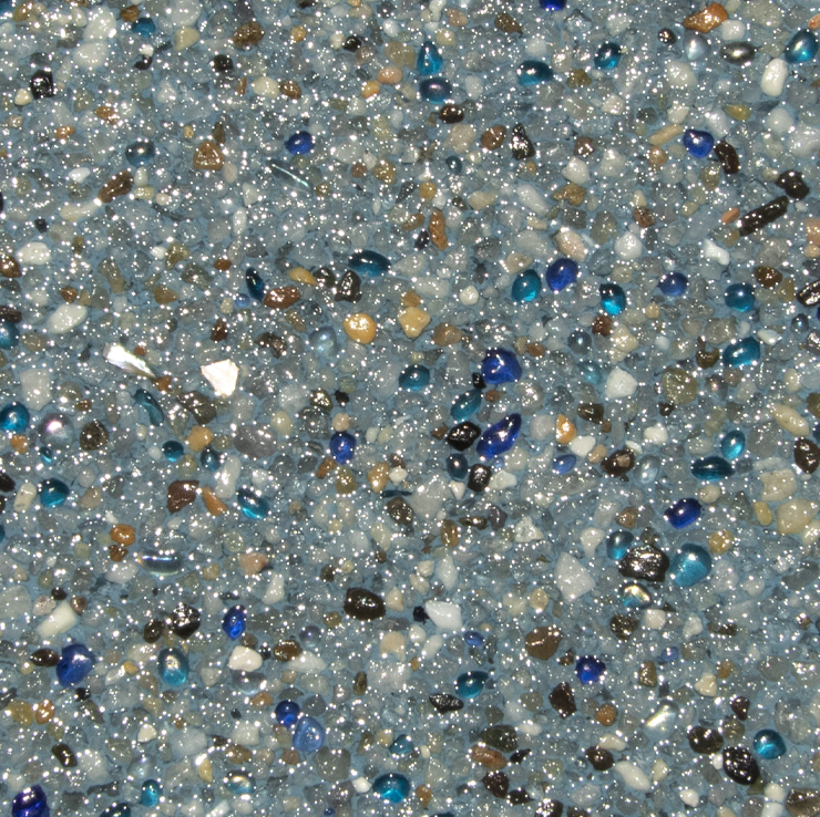 Close-up of a speckled pool surface, primarily blue, with flecks of brown, white, and dark blue.