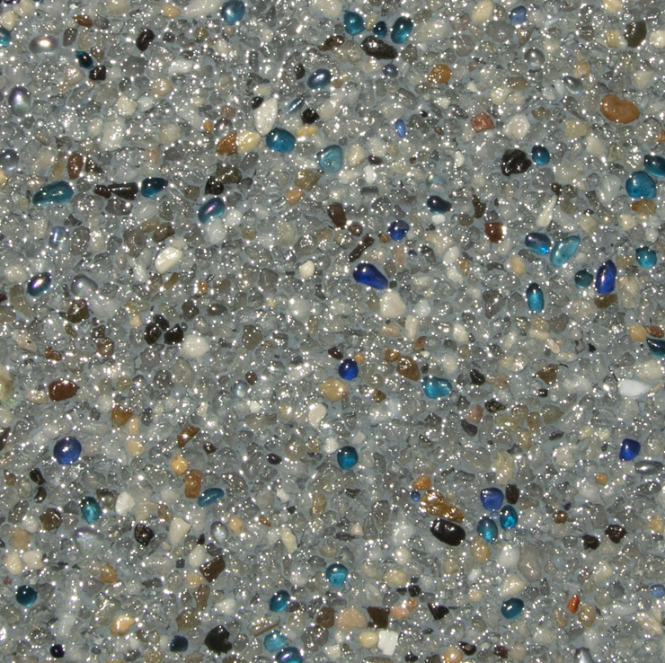 Close-up of a speckled pool finish with small, rounded pebbles in shades of gray, brown, and blue.