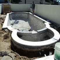 Pool construction site with a person standing inside the pool.