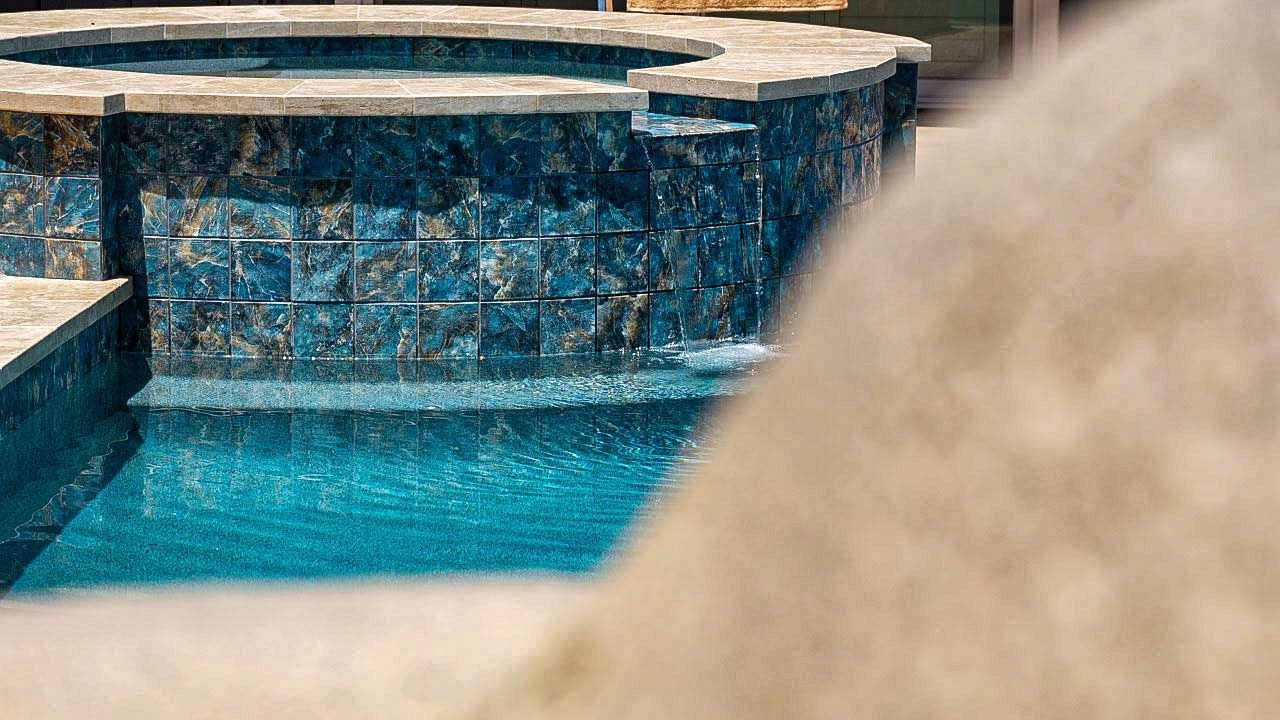 Pool with turquoise water and a blue tile waterfall feature.