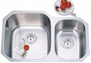 A stainless steel kitchen sink with two bowls and a plate of fruit.