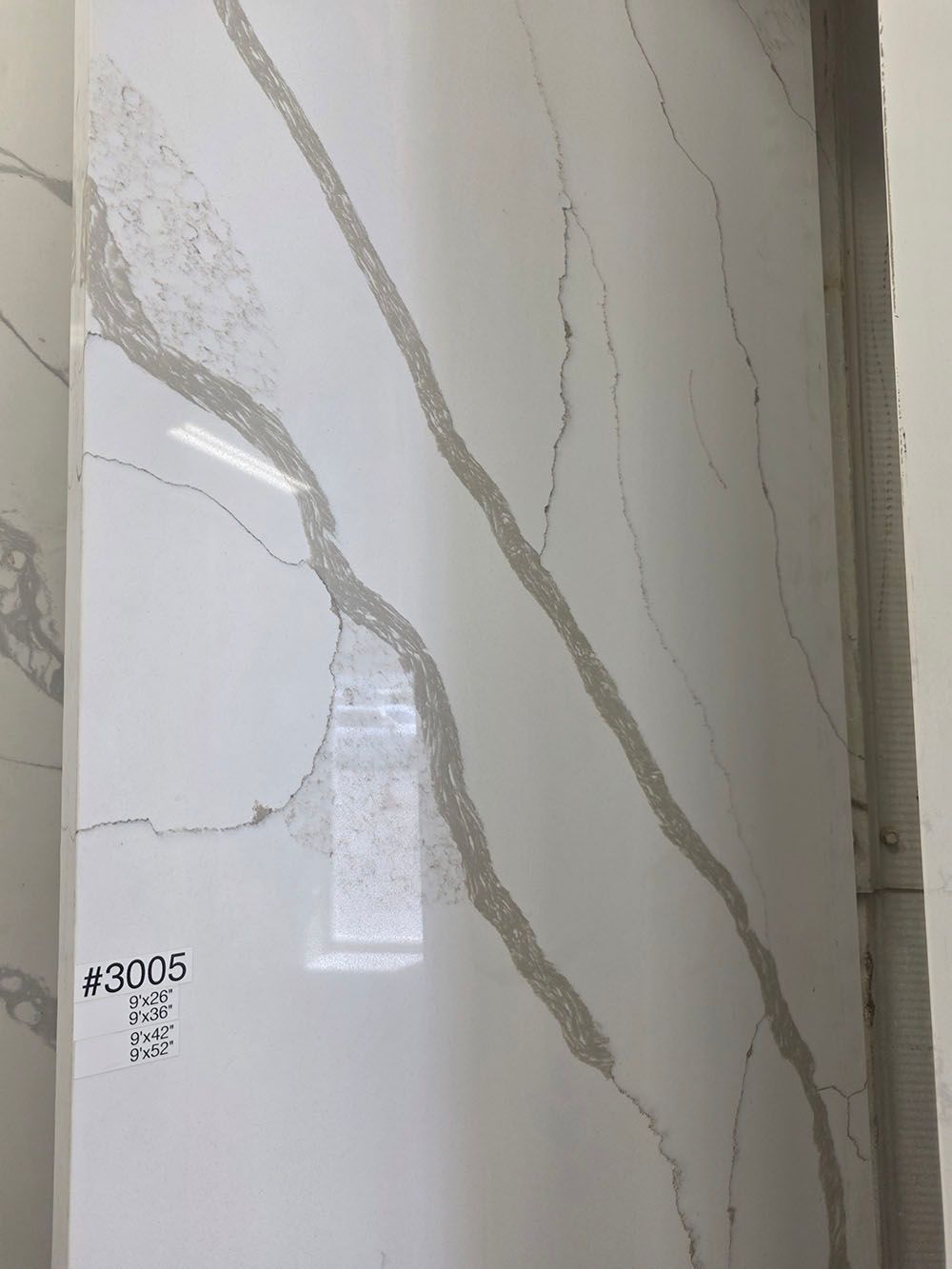 A white quartz slab with prominent, diagonal grey veining.