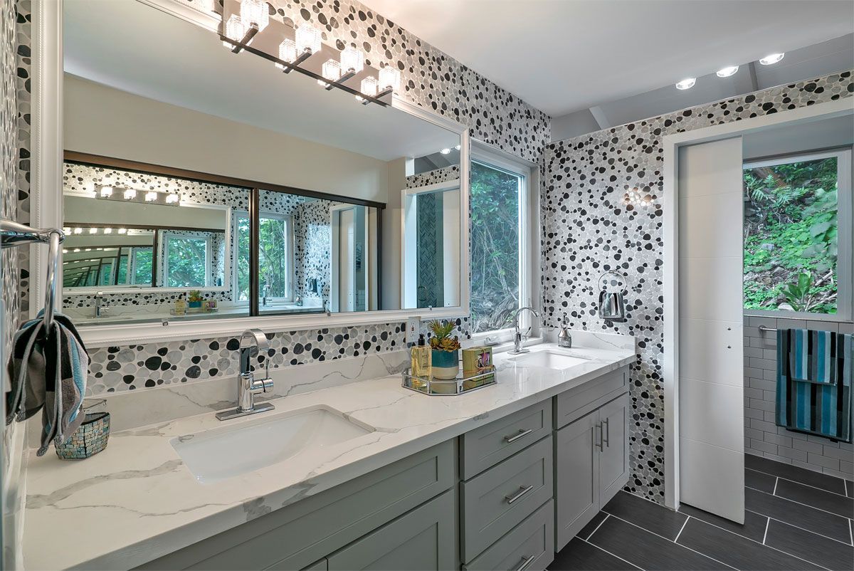 A bathroom with two sinks, a mirror, and a window.