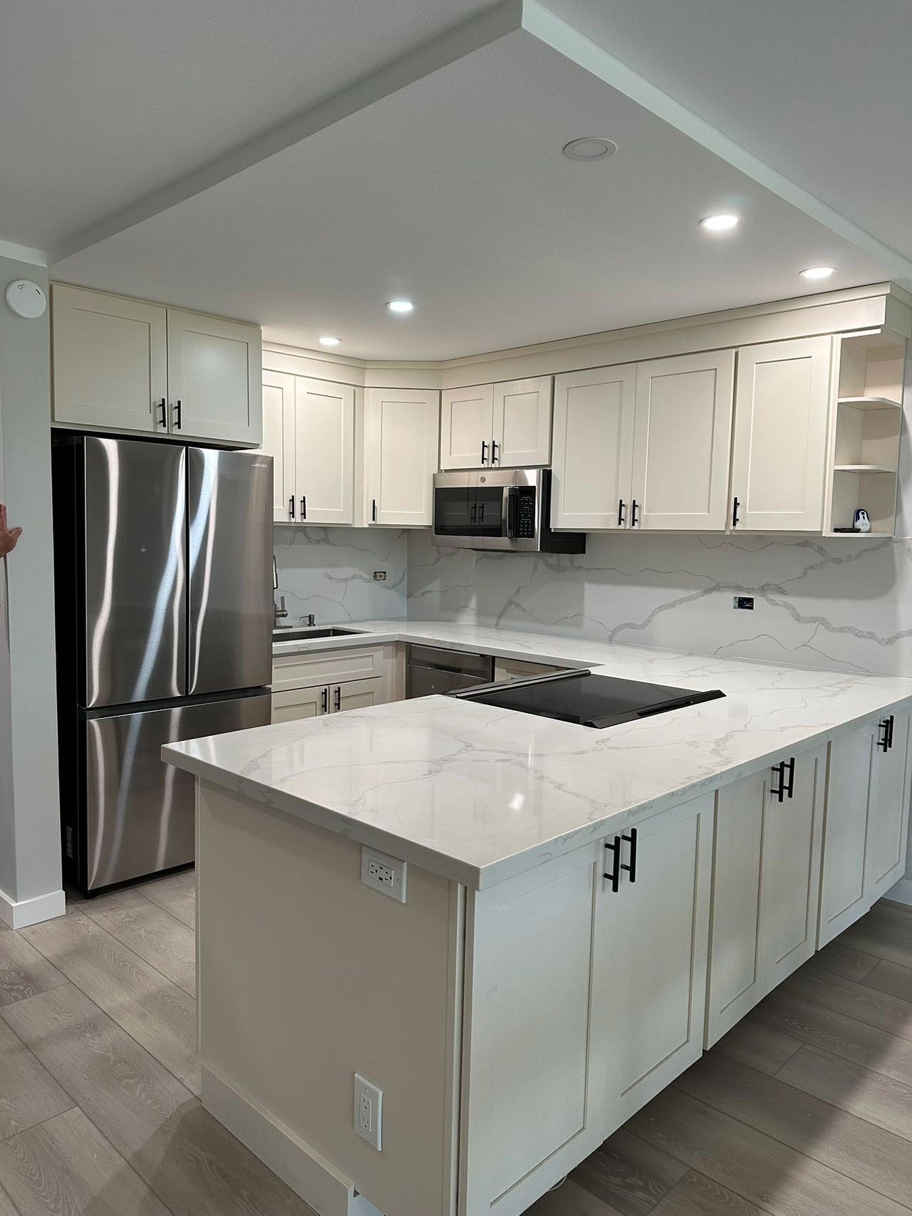 A kitchen with white cabinets and stainless steel appliances