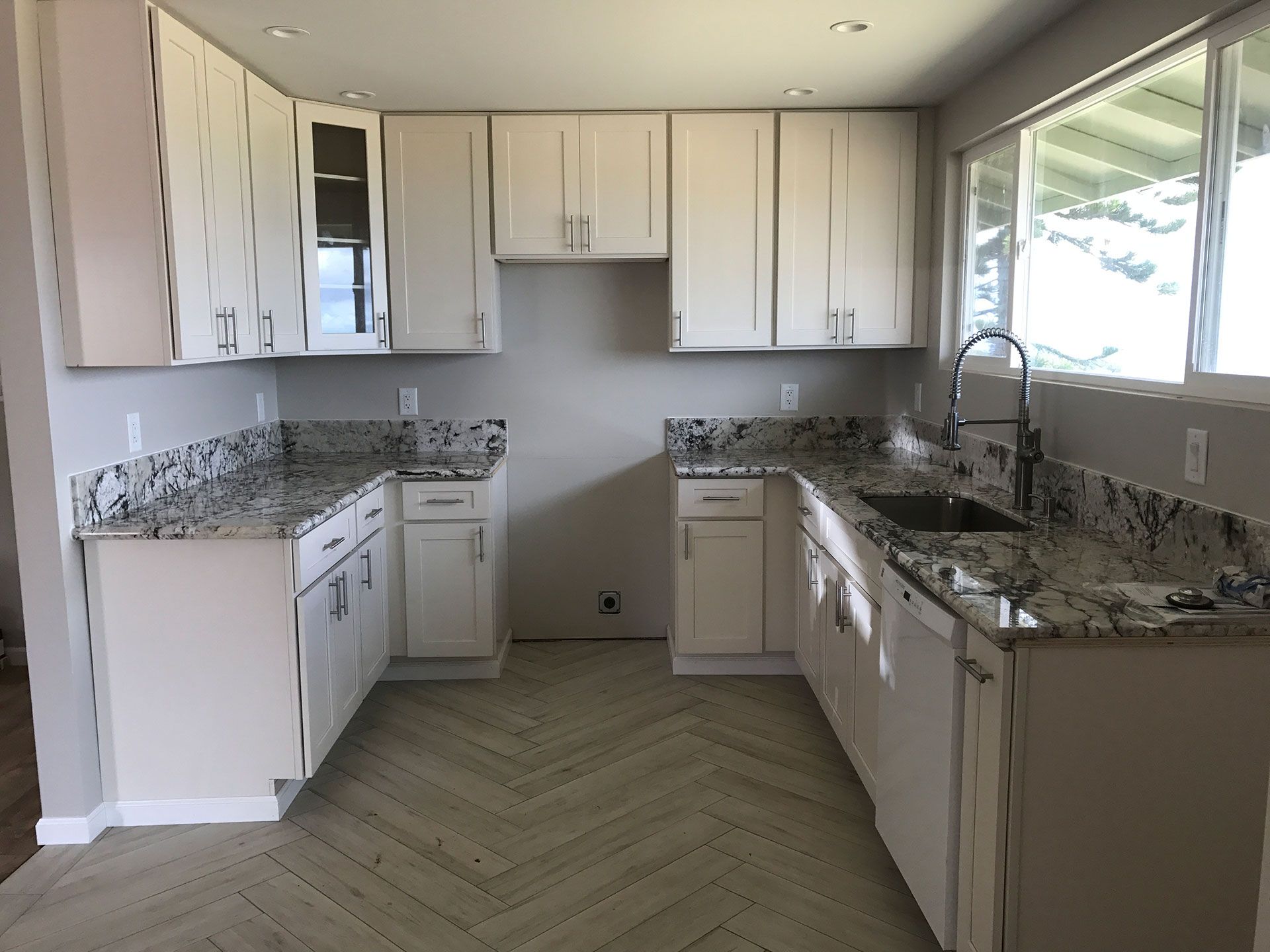 A kitchen with white cabinets and granite counter tops