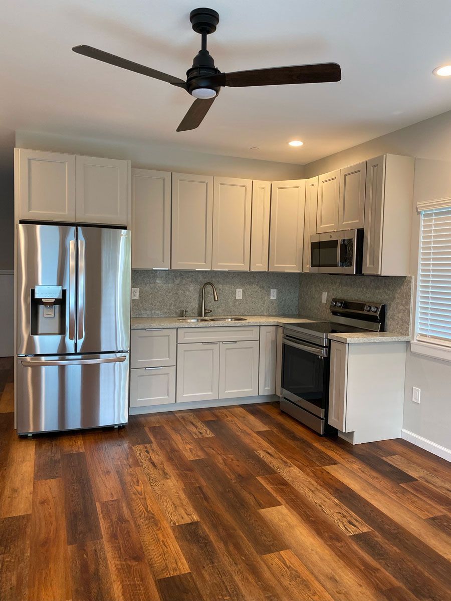 A kitchen with stainless steel appliances and a ceiling fan.