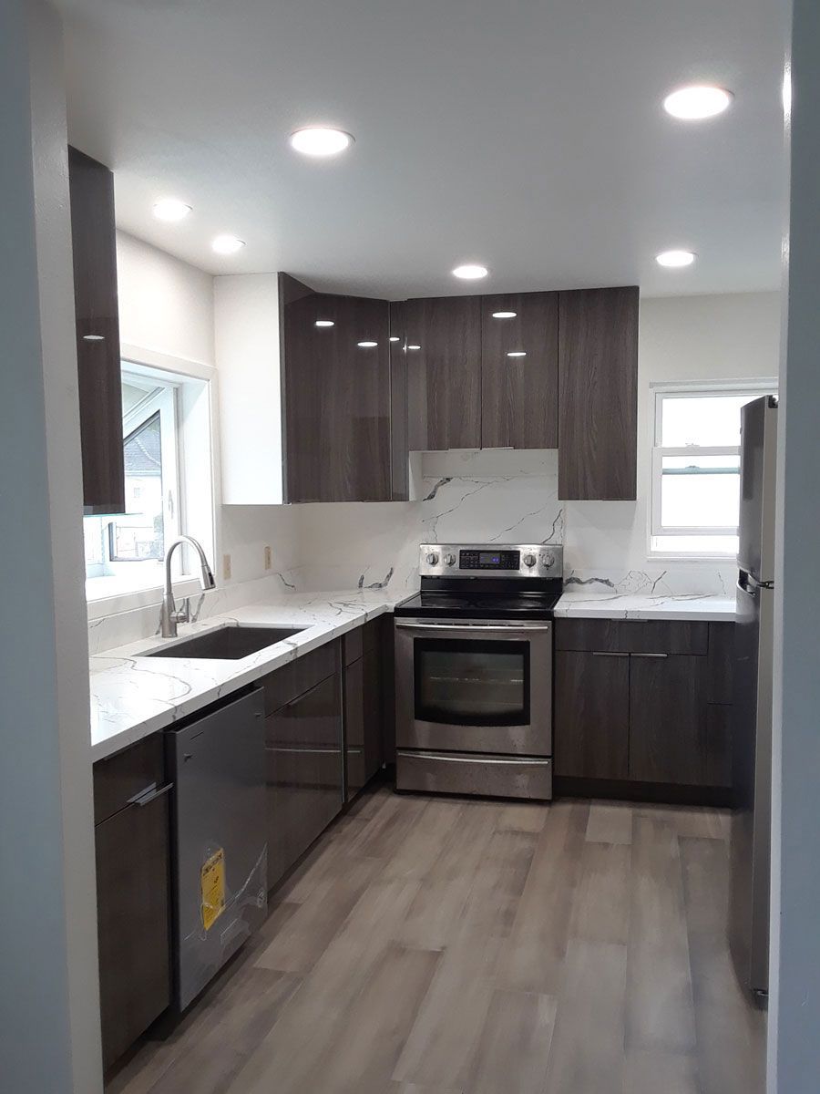 A kitchen with stainless steel appliances and wooden cabinets.