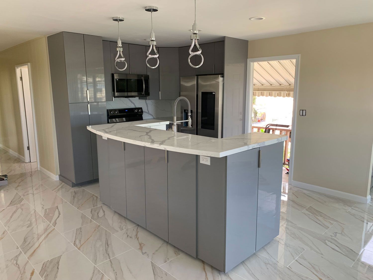 A kitchen with gray cabinets and a large island in the middle.