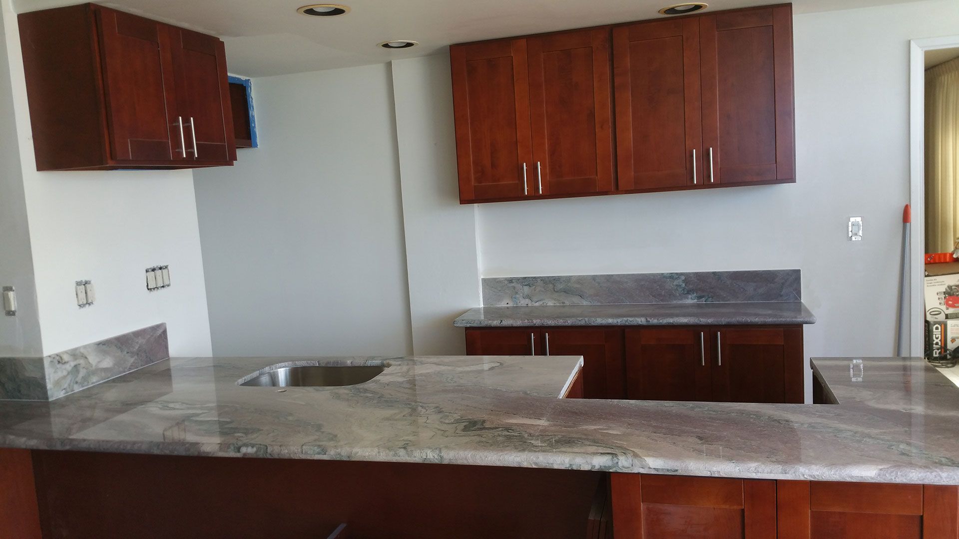 A kitchen with granite counter tops and wooden cabinets