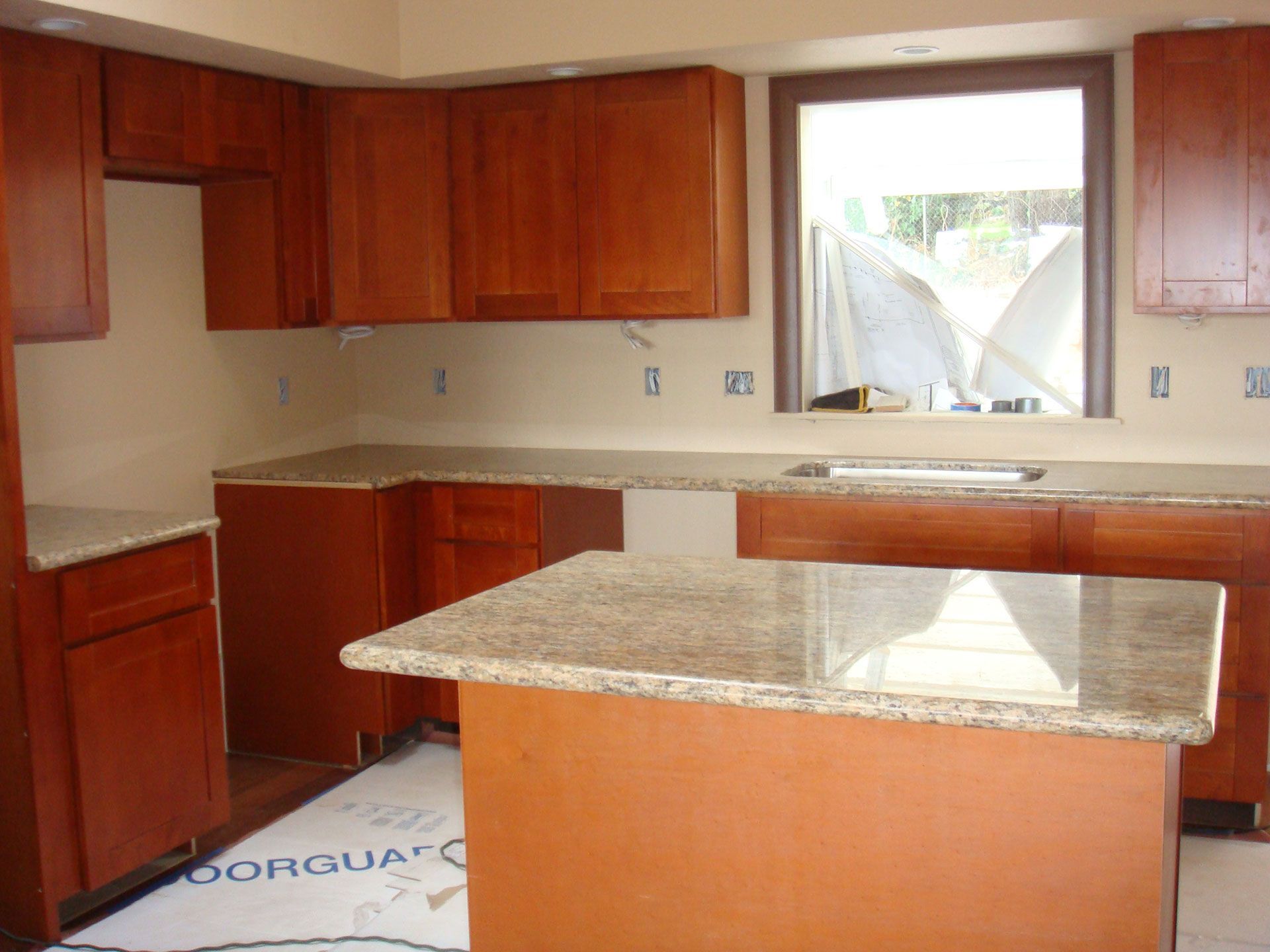A kitchen with wooden cabinets and granite counter tops