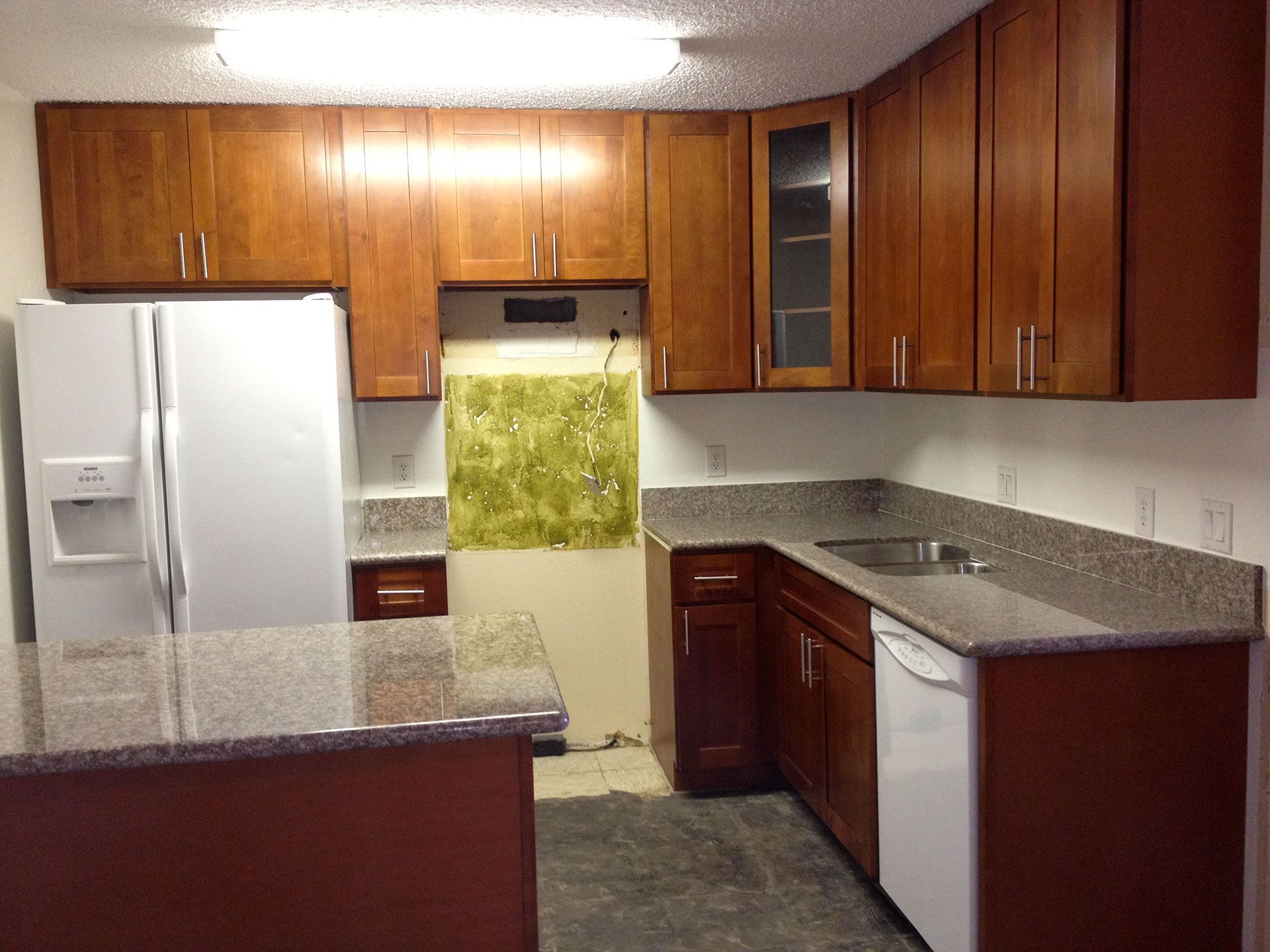 A kitchen with wooden cabinets and granite counter tops