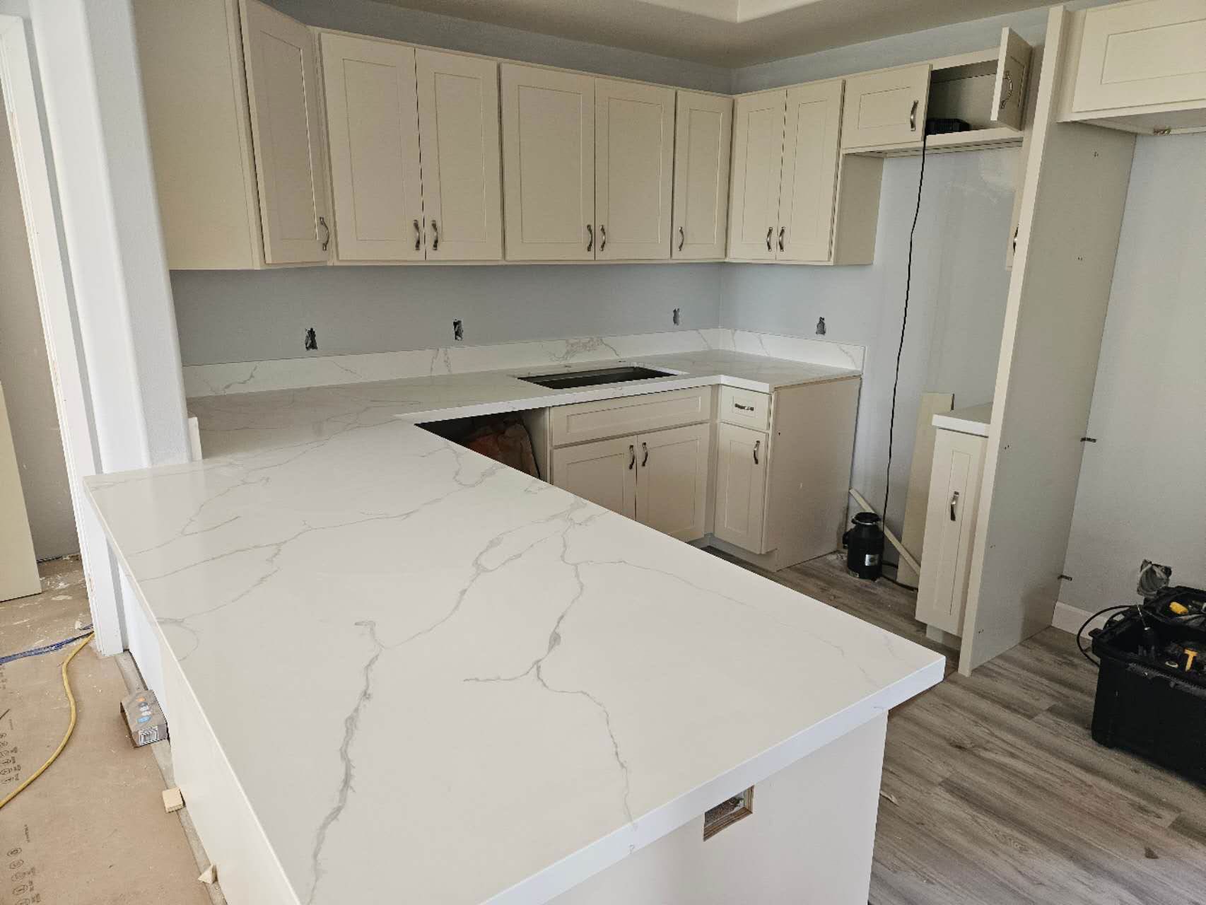A kitchen with white cabinets and a white counter top.