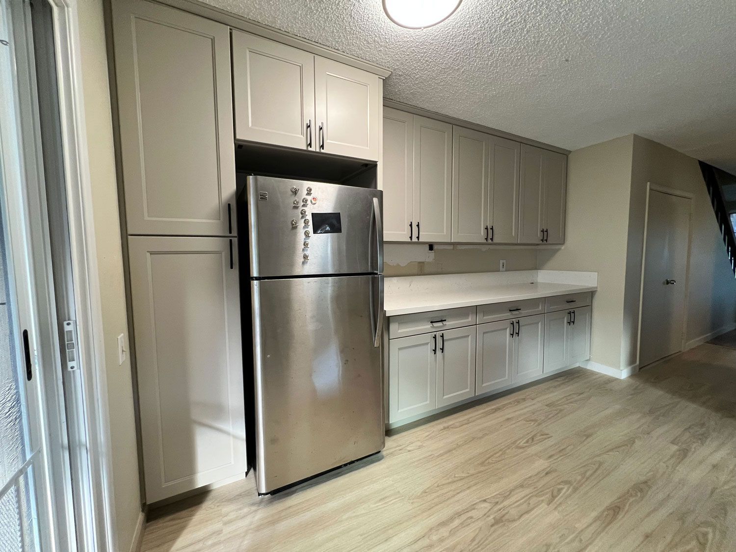 A kitchen with stainless steel appliances and white cabinets.