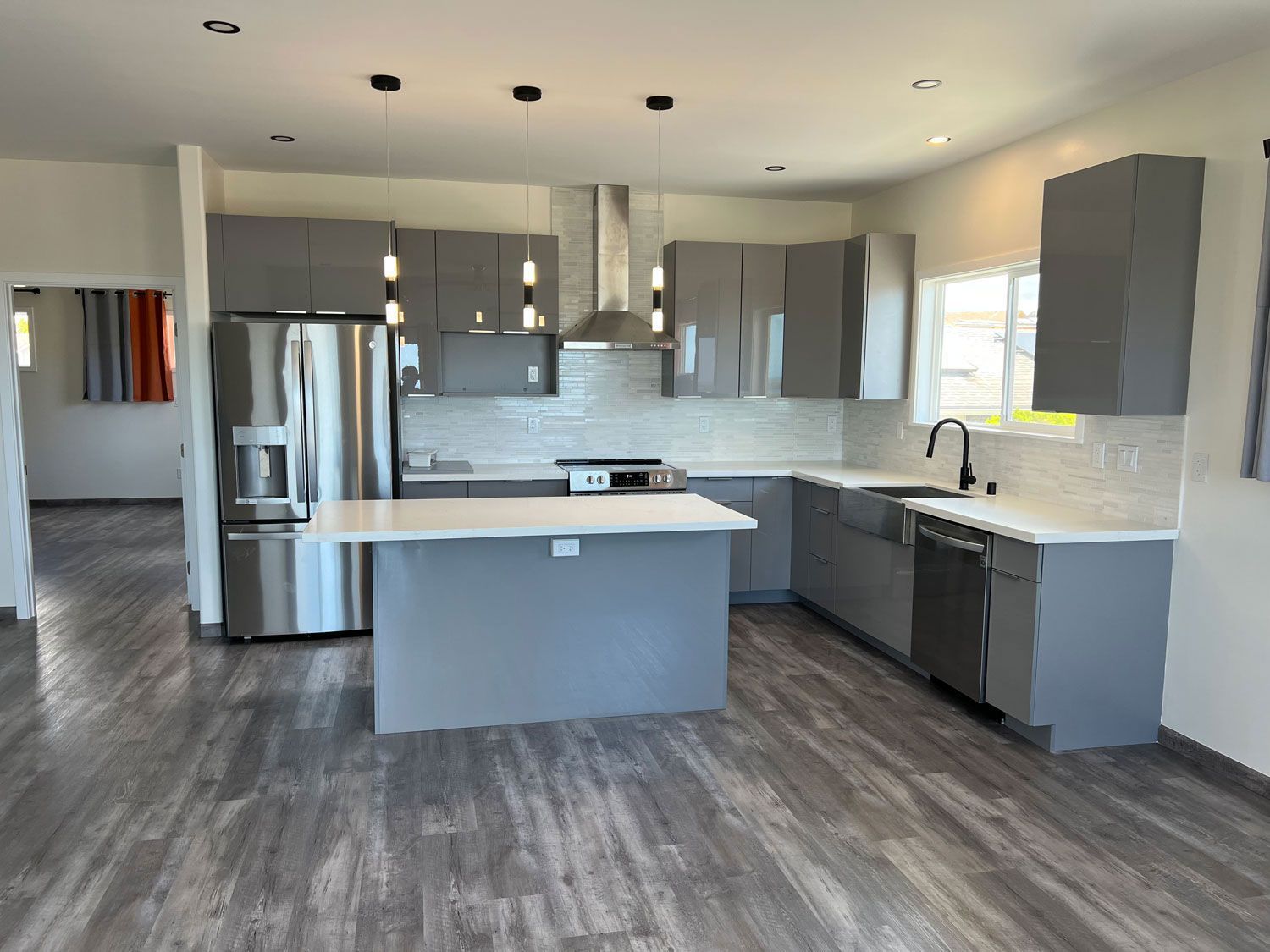 A kitchen with stainless steel appliances and gray cabinets