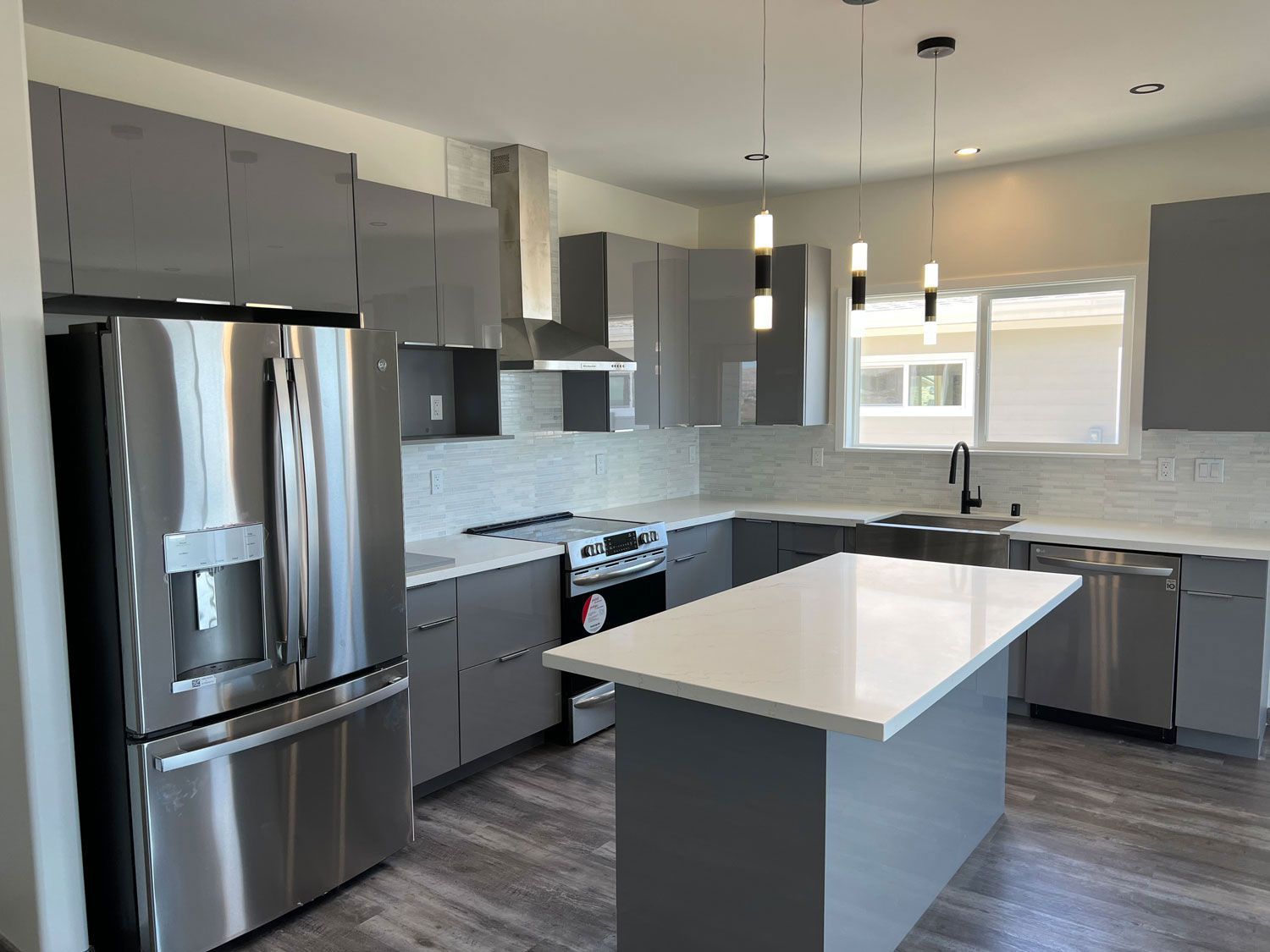 A kitchen with stainless steel appliances and gray cabinets