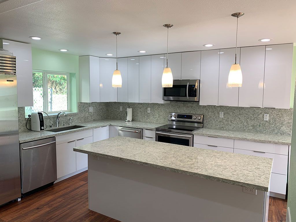 A kitchen with white cabinets and stainless steel appliances