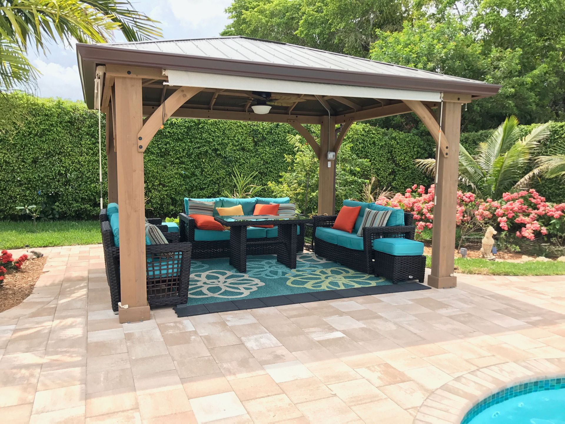 Fire pit on a patio with dogs and a putting green, lit by string lights.