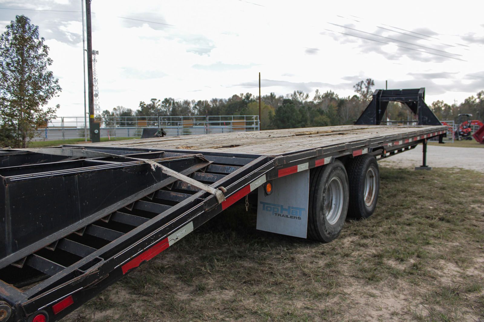 A flatbed trailer is parked in a grassy field